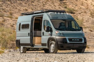 Ram Promaster camper van parked on a desert hillside with the sliding door open