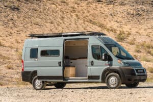 Ram Promaster camper van with the sliding door open to the galley and bench