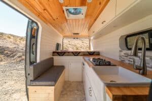 Interior looking toward the rear: storage bench, galley and farm sink