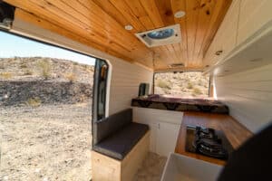 Interior from the sliding door with bench, galley and knotty pine ceiling