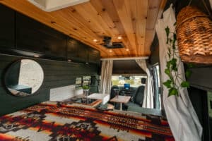Bed area with round mirror and overhead cabinets