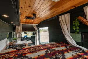 Bed with patterned blanket under the wood ceiling