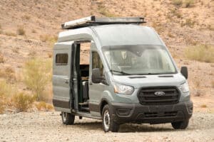 Front view of the Ford Transit camper van with roof rack and open sliding door