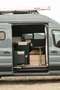 Side of the Transit with the sliding door open to the galley and fridge