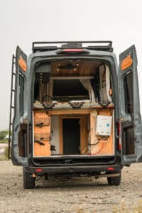 Rear doors open showing the bed platform storage and electrical service box