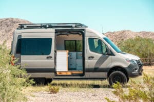 Side view of the Sprinter camper van with Flarespace flares and sliding door open to the galley