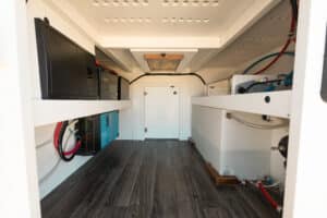 Interior with the bed platform removed, showing the floor, electrical cabinet and water service area