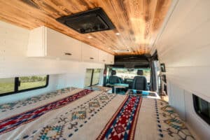 Bed and overhead cabinet storage under the wood ceiling