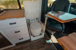 Laveo dry flush toilet in its cabinet next to the swivel seat
