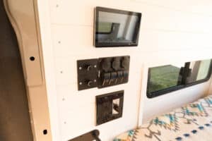 Wall-mounted control panel and LED rocker switch panel above the bed
