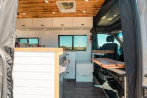 Interior from the rear with white cabinetry, teak counters and wood ceiling