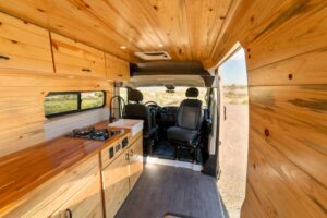 Interior looking forward past the walnut butcher block counter and gas stove to the swivel cab seats